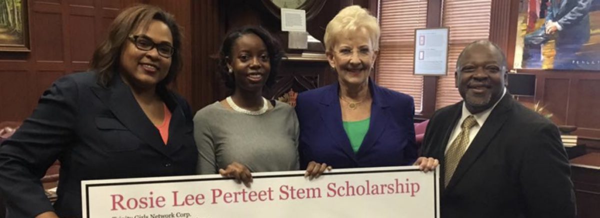 women and a man smiling while holding a scholarship grant certificate